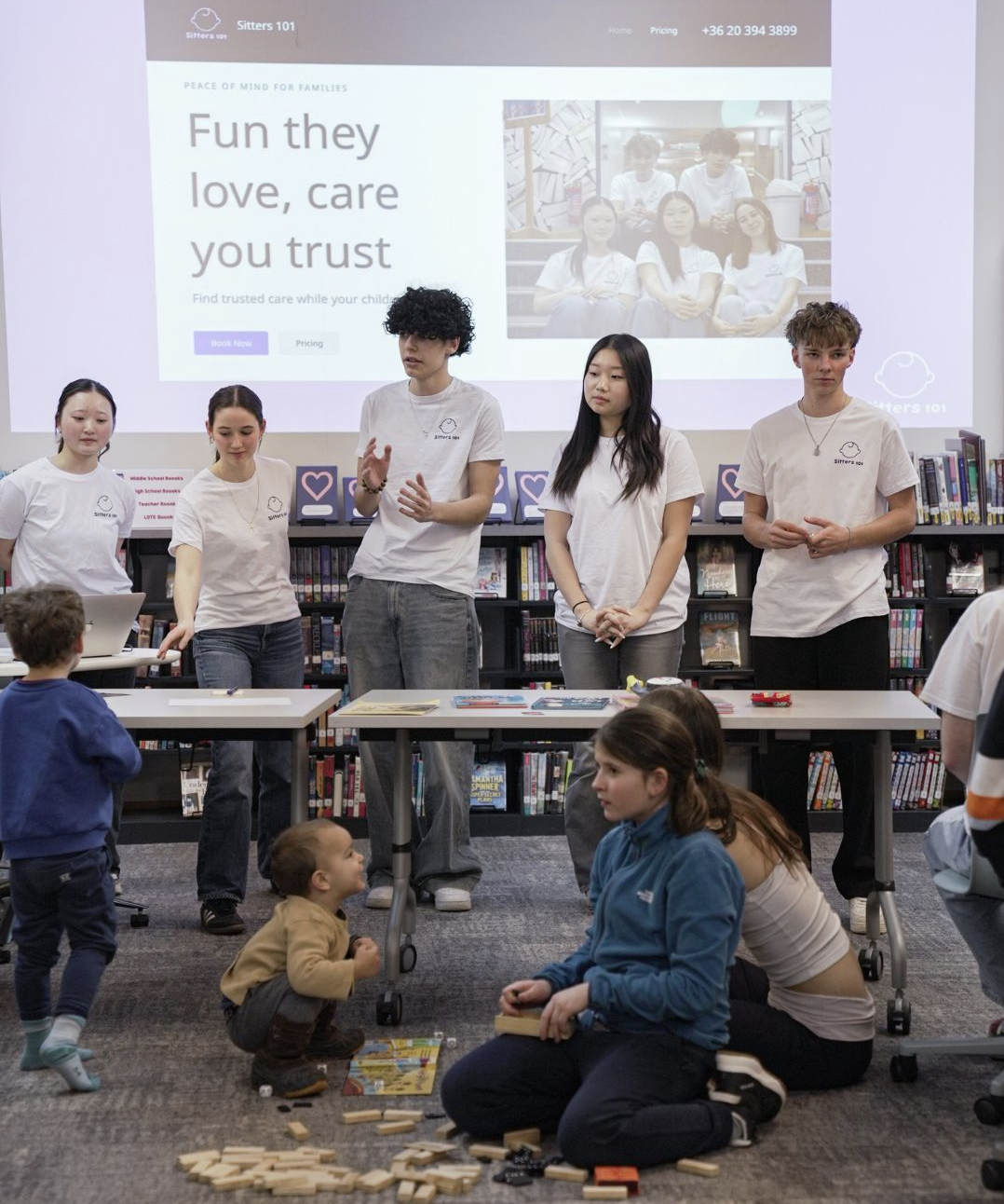 GID students presenting a Sitters 101 session to younger children in a school library.